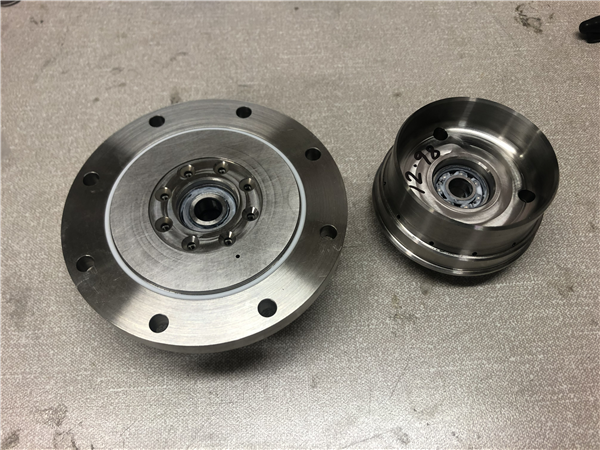 The machined end caps with ball bearings fitted.